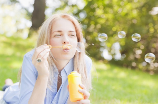USA, New York, New York City, Manhattan, Central Park, Woman blowing bubbles. Photo: Daniel Grill