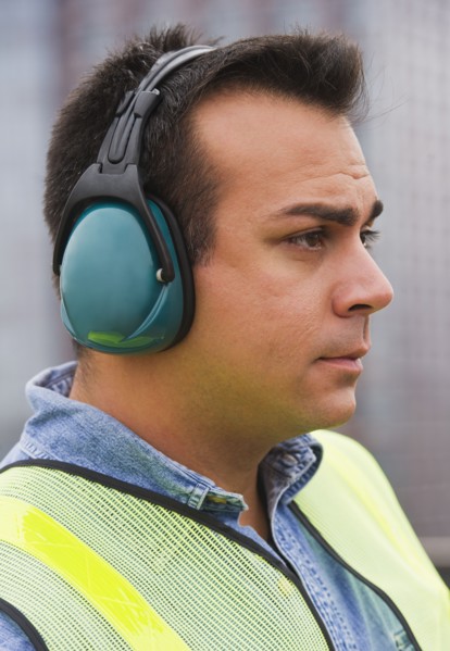 Construction worker wearing reflective clothing and headphones. Photo : Daniel Grill