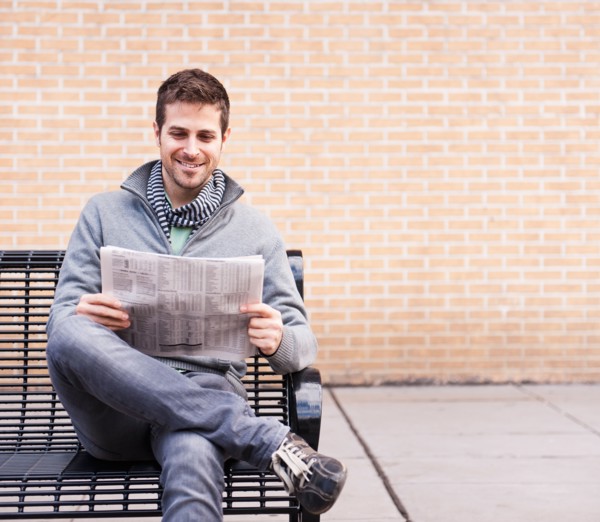 Man on bench reading newspaper. Photo : Daniel Grill