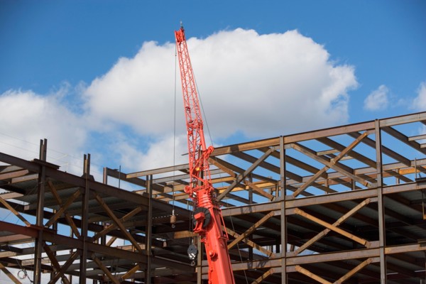 Unfinished structure and crane at construction site. Photo : fotog
