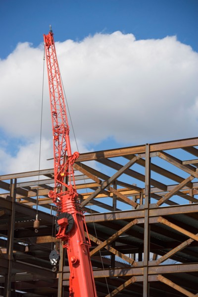 Unfinished structure and crane at construction site. Photo : fotog