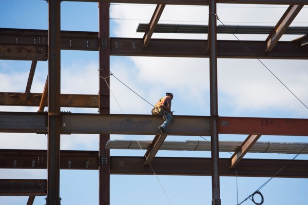 Construction worker working on unfinished structure. Photo : fotog