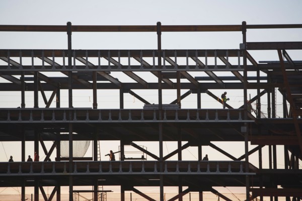 Group oaf construction workers working on unfinished structure. Photo : fotog