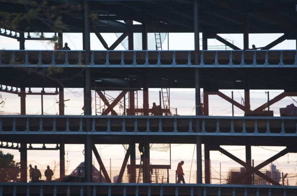 Group oaf construction workers working on unfinished structure. Photo : fotog