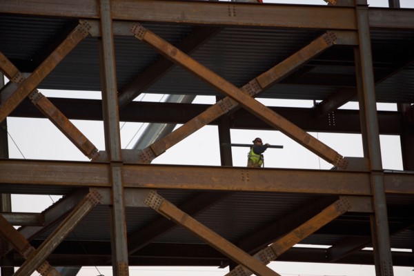 Construction worker working on unfinished structure. Photo : fotog