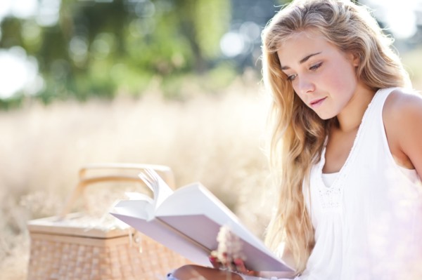 Teenage girl (16-17) reading book outdoors. Photo : Take A Pix Media