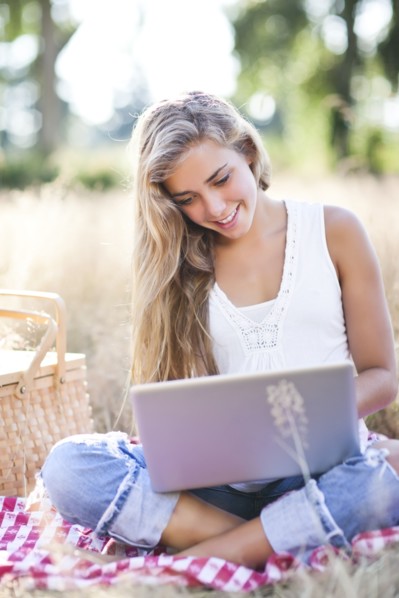Teenage girl (16-17) using laptop outdoors. Photo: Take A Pix Media