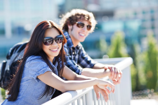 Couple standing by banister outdoors. Photo : Take A Pix Media