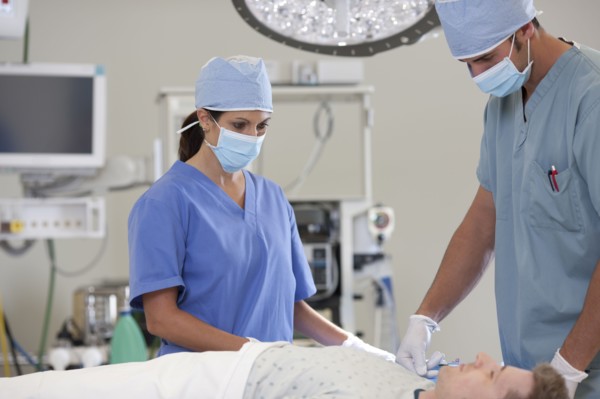 Surgeons preparing patient for surgery. Photo : db2stock