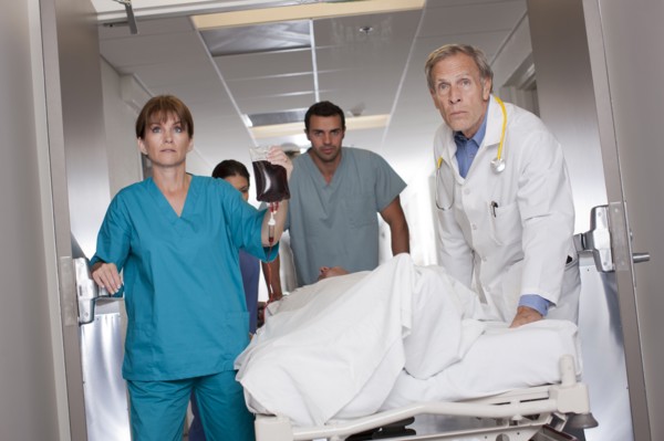Team of doctors wheeling in patient. Photo : db2stock