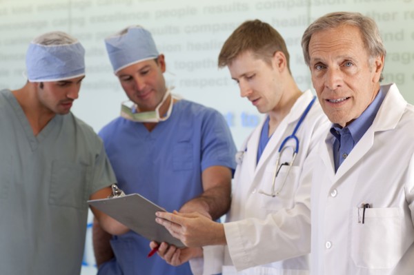 Doctors and surgeons discussing on medical record. Photo: db2stock