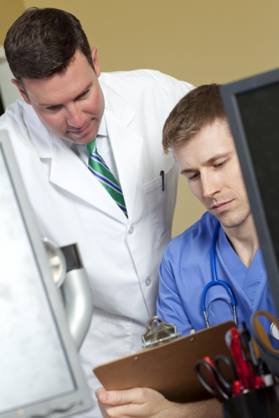 Doctor and surgeon reading medical record in doctor's office. Photo : db2stock