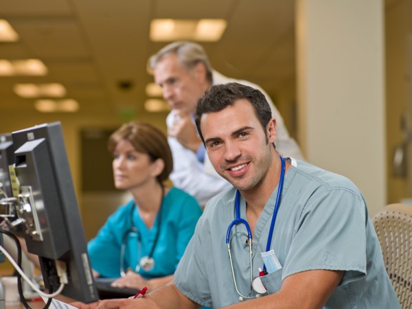 Doctor and surgeons working on computers in hospital. Photo : db2stock