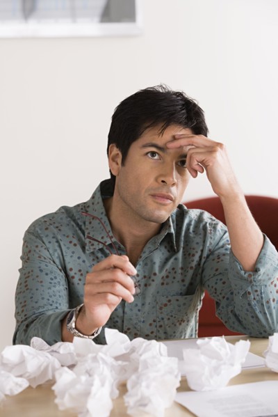 Businessman with crumpled paper balls. Photo: Rob Lewine