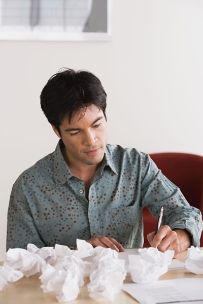 Businessman with crumpled paper balls. Photo: Rob Lewine