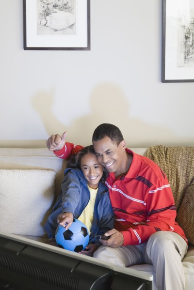 Father and Daughter (10-11) watching tv. Photo : Rob Lewine