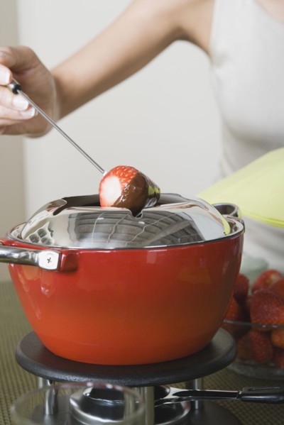Woman dipping strawberries in chocolate mousse. Photo: Rob Lewine