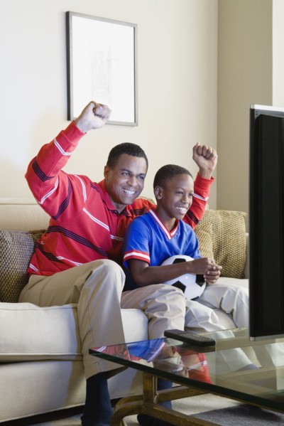 Father and Son (12-13) watching sports on tv. Photo : Rob Lewine
