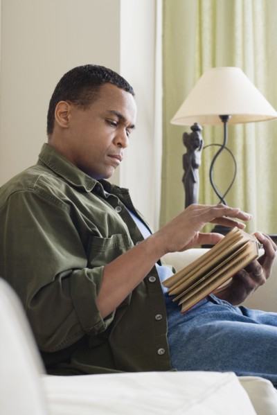 Man reading book at home. Photo : Rob Lewine