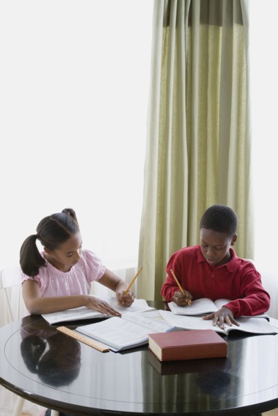 Brother and sister (12-13) doing homework. Photo : Rob Lewine