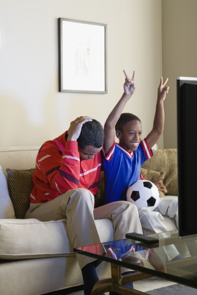 Father and Son (12-13) watching sports on tv. Photo: Rob Lewine