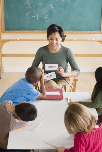Female teacher with pupils (6-7) in classroom. Photo: Rob Lewine
