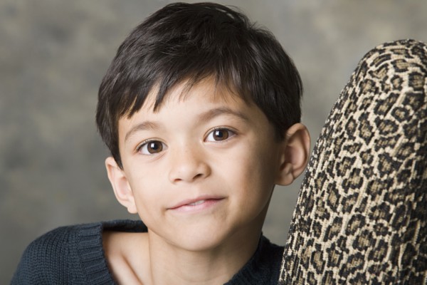 Portrait of smiling boy (8-9) looking at camera, studio shot. Photo : Rob Lewine