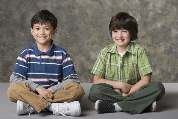 Portrait of two boys (6-7, 8-9) smiling, studio shot. Photo : Rob Lewine