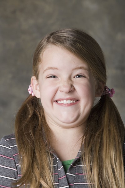 Portrait of smiling girl (8-9), studio shot. Photo : Rob Lewine