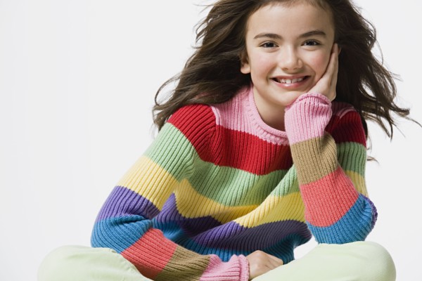 Portrait of smiling girl (8-9), studio shot. Photo : Rob Lewine