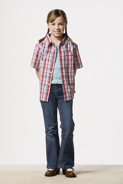 Portrait of smiling girl (8-9) wearing checked shirt, studio shot. Photo : Rob Lewine