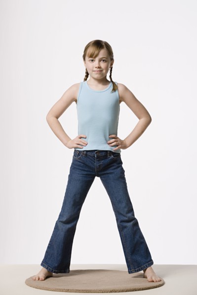 Portrait of girl (8-9) with hands on hips, studio shot. Photo : Rob Lewine