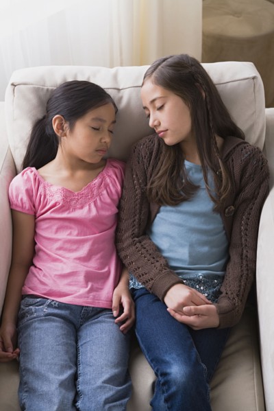 Girls (8-9, 10-11) sleeping in armchair. Photo : Rob Lewine