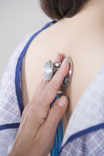 Close up of doctor's hand examining woman with stethoscope. Photo: Rob Lewine