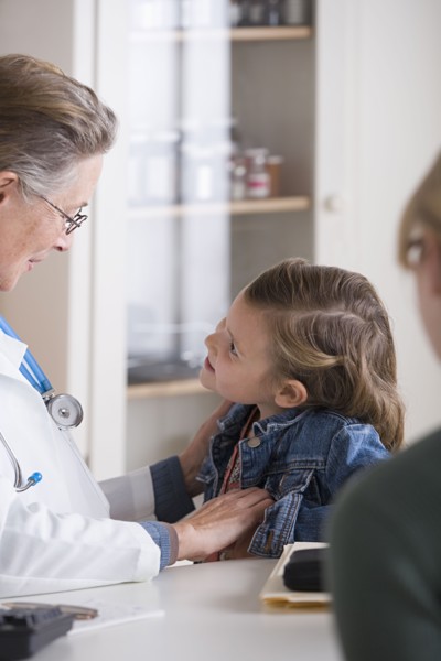 Female doctor talking to small girl (4-5) in her office. Photo: Rob Lewine
