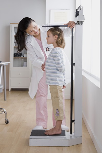 Female doctor measuring small girl (4-5). Photo: Rob Lewine