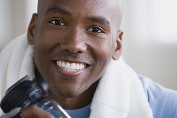 Portrait of smiling young man in gym. Photo : Rob Lewine