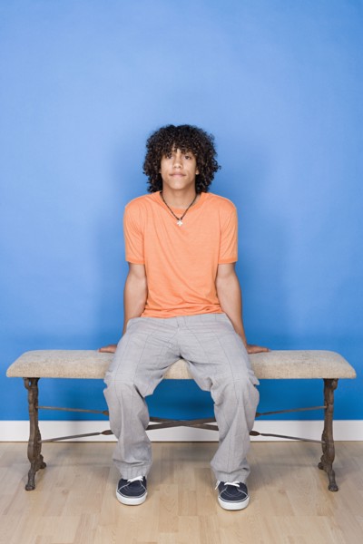 Portrait of teenage boy (14-15) sitting on bench. Photo : Rob Lewine