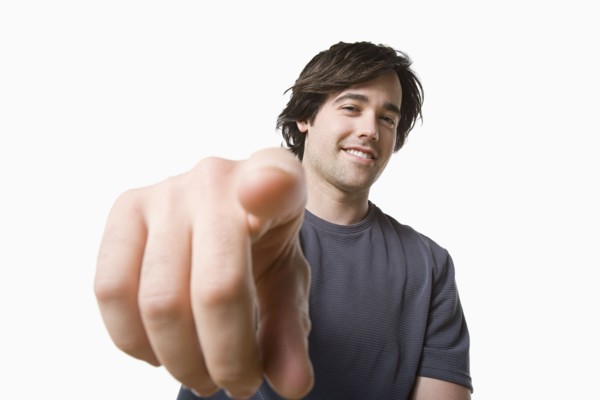 Studio portrait of young man pointing. Photo: Rob Lewine