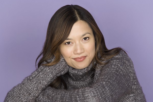 Portrait of smiling woman on purple background, studio shot. Photo: Rob Lewine