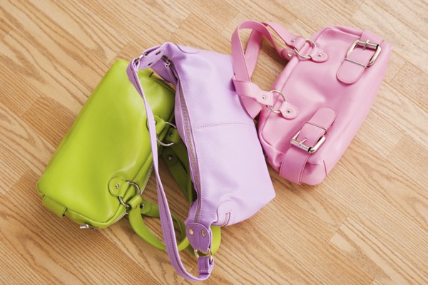 Close up of three colorful purses on parquet floor. Photo : Rob Lewine