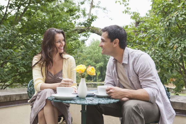 Happy couple sitting at table at outdoor cafe. Photo : Tetra Images