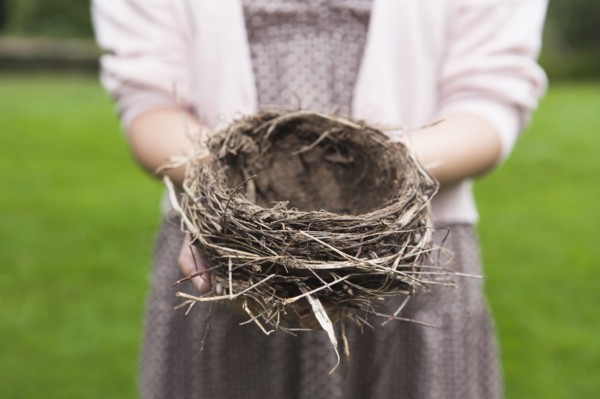 Happy woman standing on stone wall on field. Photo : Tetra Images