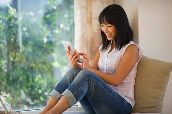 Smiling mid adult woman using digital tablet.