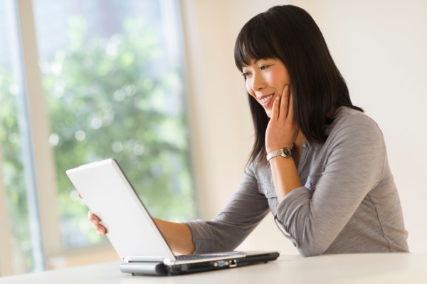 Smiling woman using laptop.