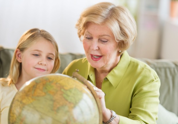 Grandmother with granddaughter (8-9) looking at globe.
