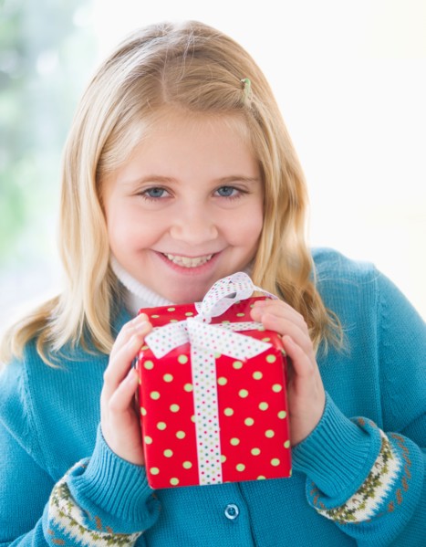 Portrait of smiling girl (8-9) holding gift.