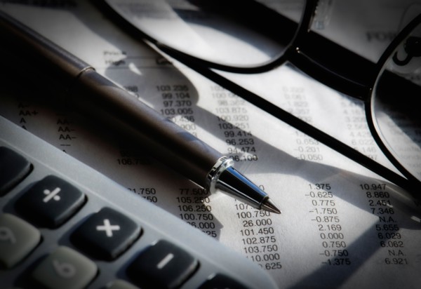 Close up of pen, glasses and calculator, studio shot.
