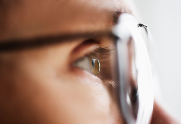 Close up of men's eye looking through glasses.