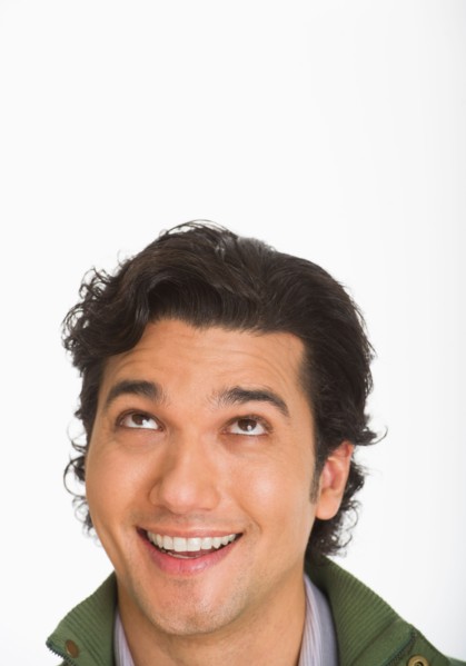 Studio shot of young man looking up.